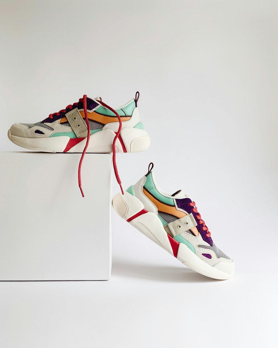 pair-of-white-and-orange-athletic-shoes-on-white-box-dwkihoqqxk8