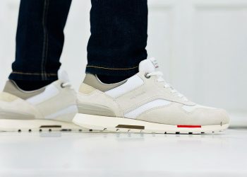 Fashionable close-up of white casual sneakers and jeans indoors.